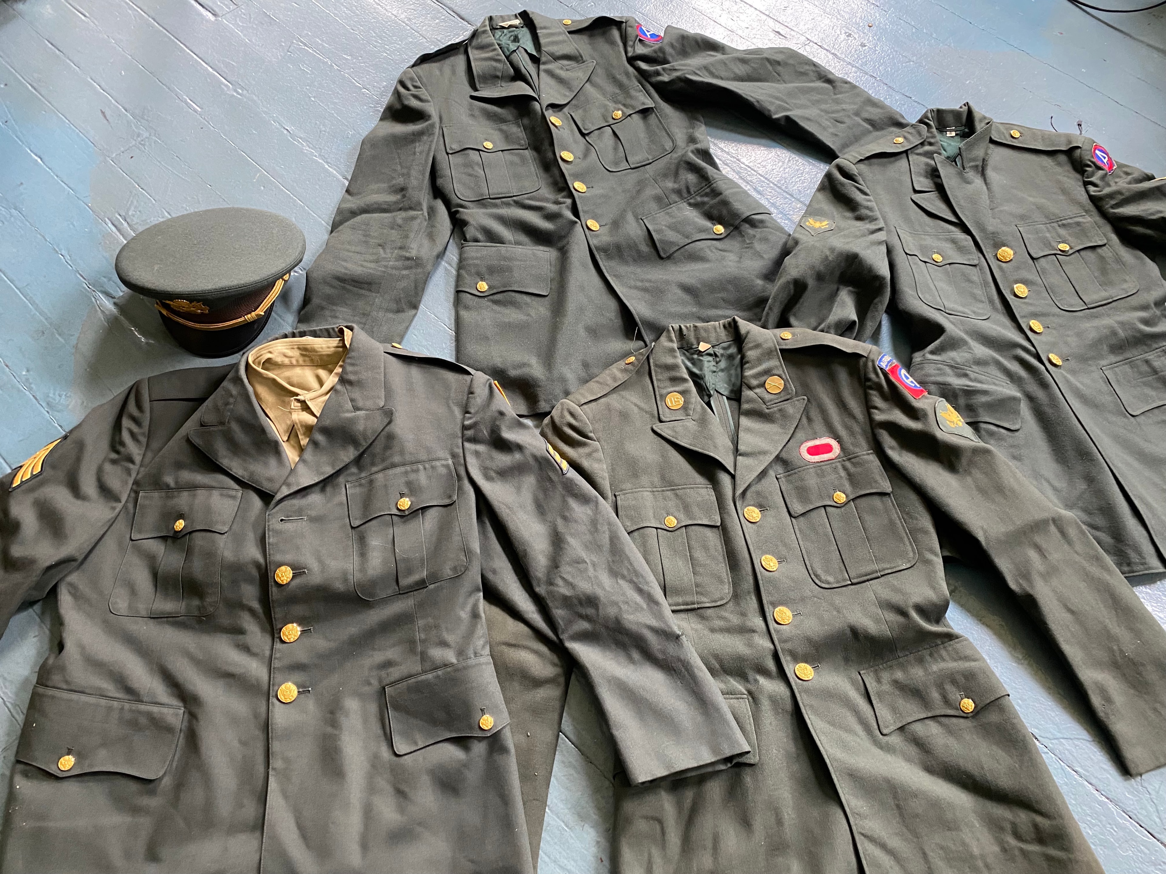 Collection of Army wool tunics with patches and officer cap