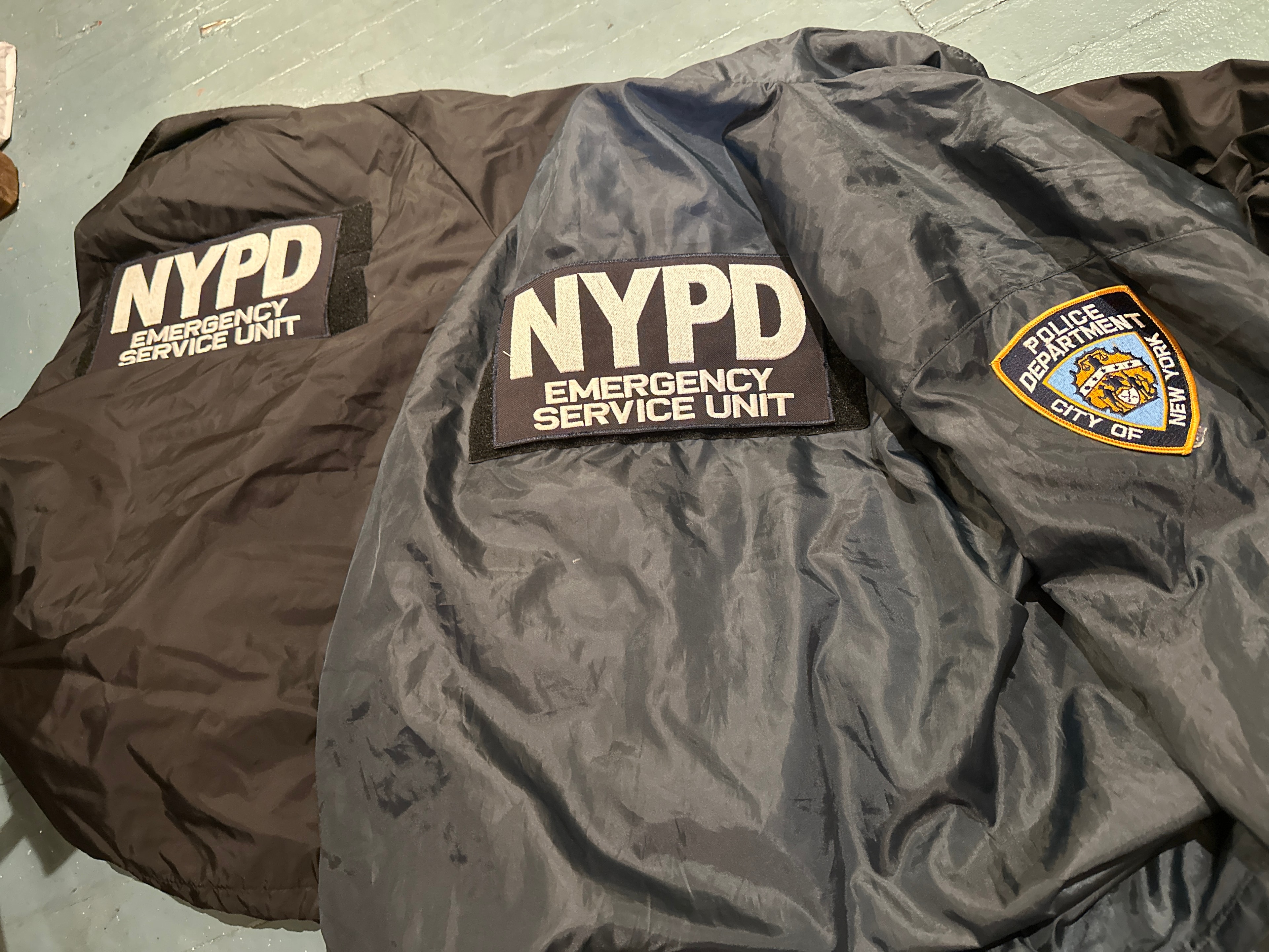 NYPD Emergency Service Unit windbreakers — black and grey nylon jackets with ESU back patch and NYPD Police Department City of New York shield