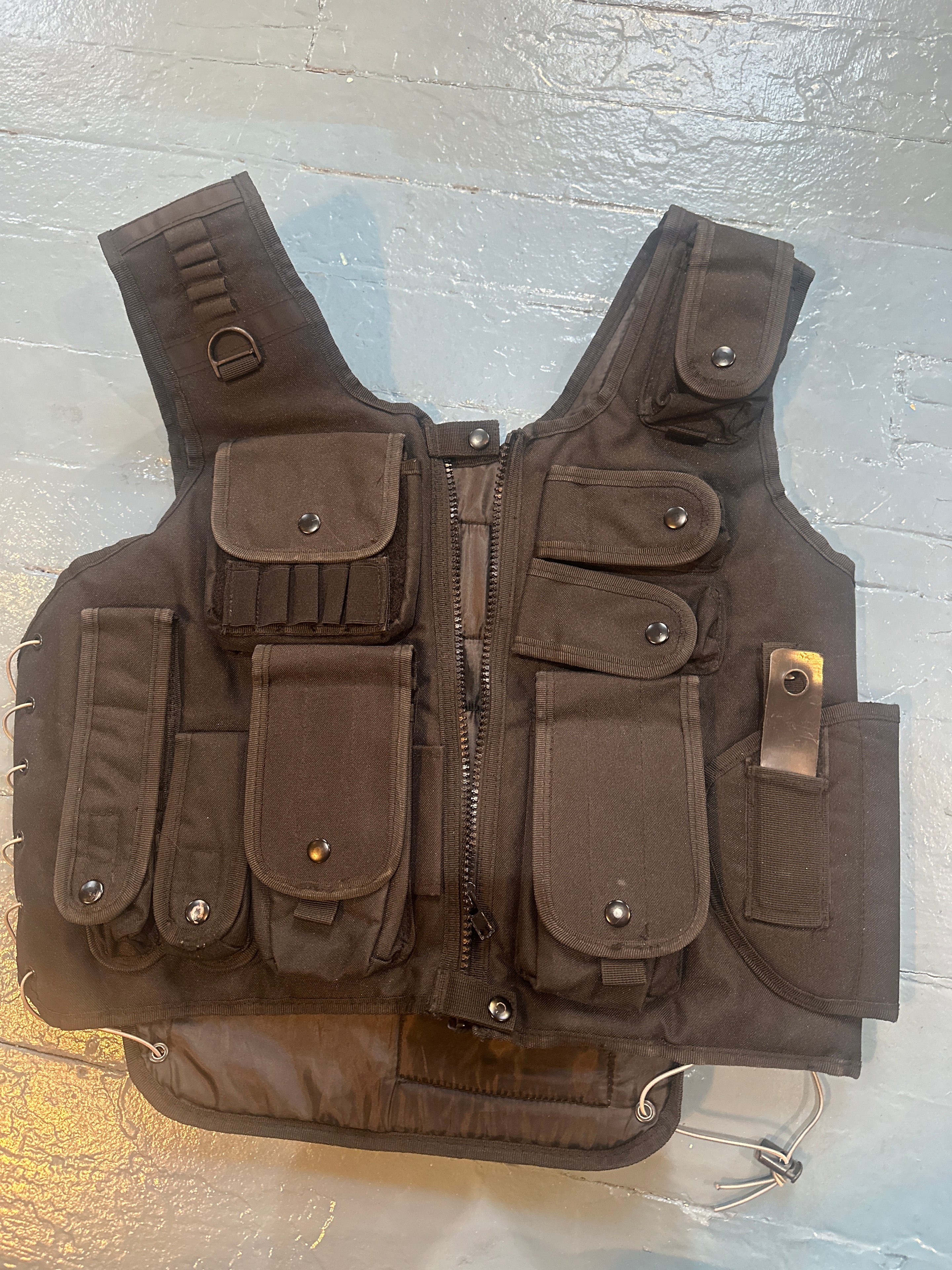Black SWAT tactical vest with multiple MOLLE pouches, magazine holders, and zippered compartment