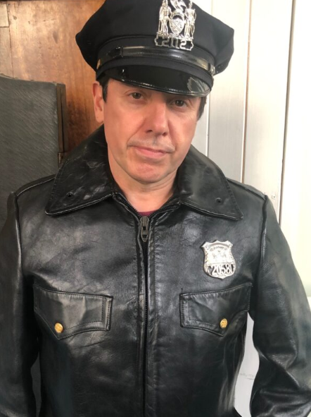 NYC Police officer in black leather jacket and cap with badge