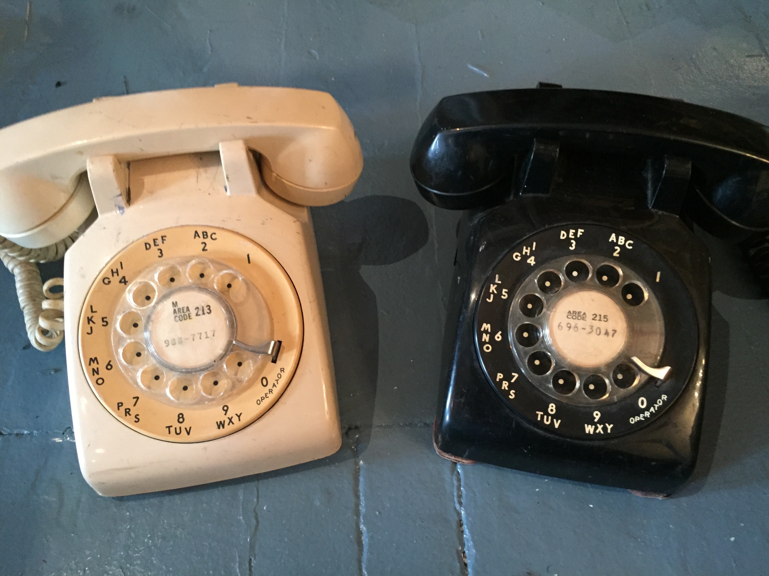 Vintage ivory and black rotary dial telephones with original area code labels